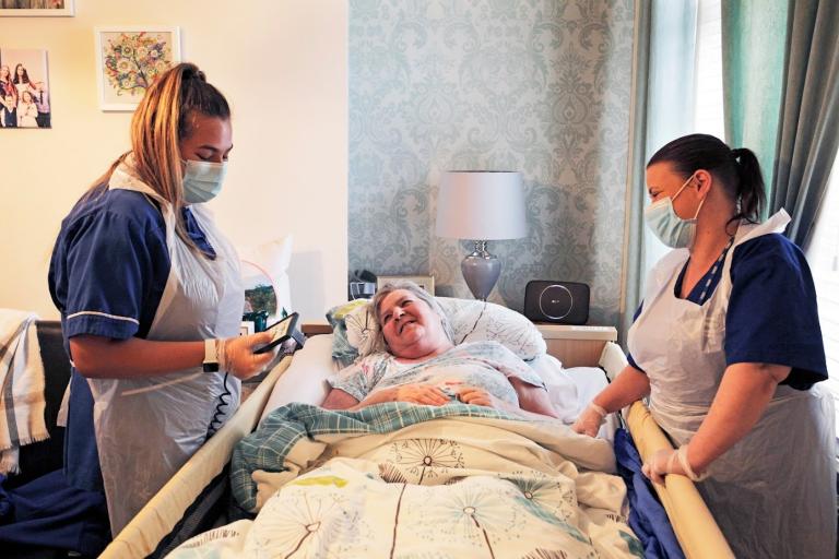 Jasmine Gray(left hand side) and Linda Teasdale (right hand side) talking to an old resident of the home who is bedridden
