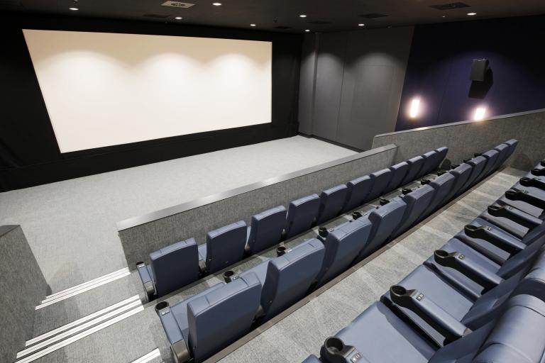 New, black chairs in front of a cinema screen in one of the cinema rooms