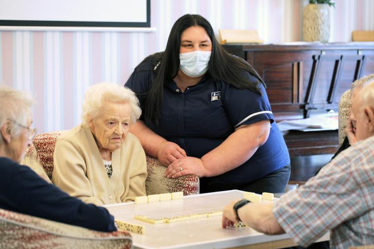 Deputy Manager of Sand Banks Care Centre, Leanne Manson talking to three old residents of the home staying around a table