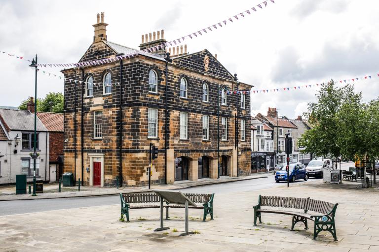 Image of Guisborough Town Hall with cars driving through Westgate