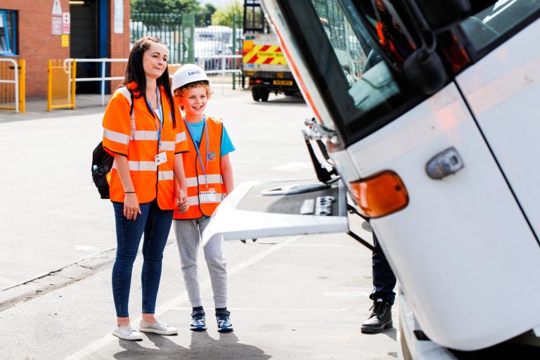 Image of a young boy and his mother in front of a bin wagon in the parking lot of the Redcar and Cleveland Central Depot