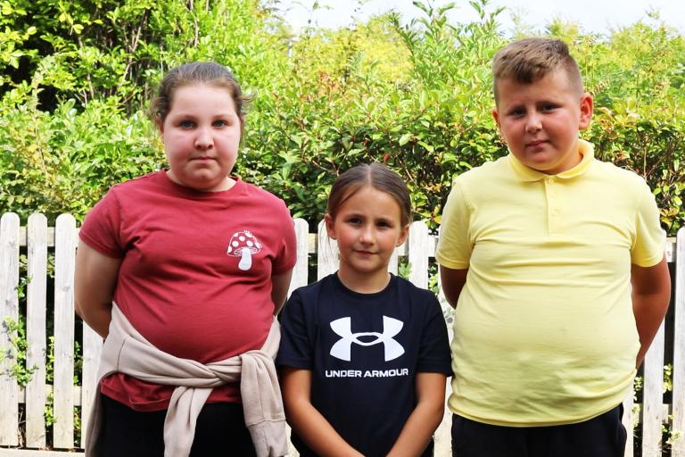 Image of three school children talking about the importance of recycling.