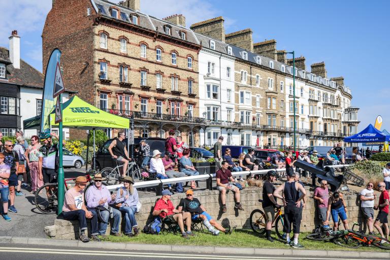 Crowds watching the the Road Race with houses in the background.