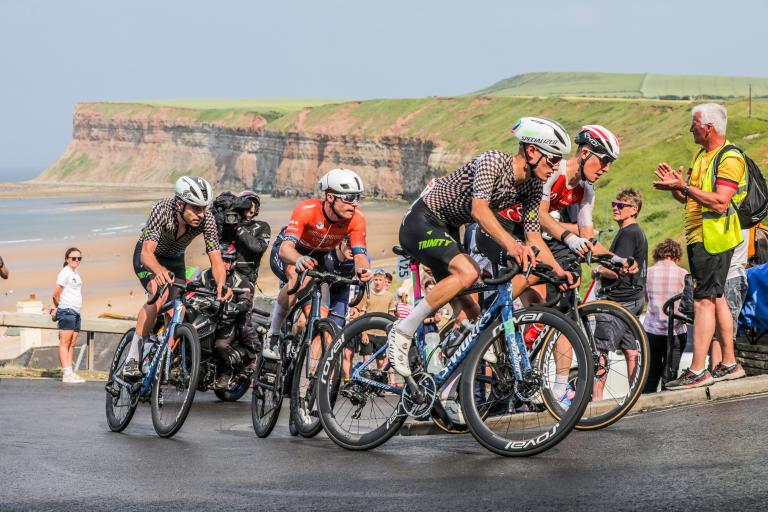 Cyclists at the Road Race going up the Saltburn bank with the Saltburn Cliffs in the background.