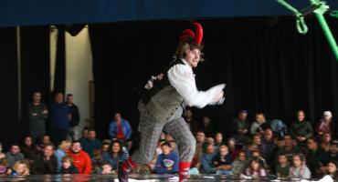 Image of a man wearing a red hat performing to crowd. 