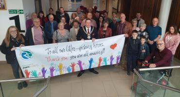 a group of many people smiling to the camera with a banner in front of them that reads: "To our litter picking heroes: Thank you, you are all amazing!""