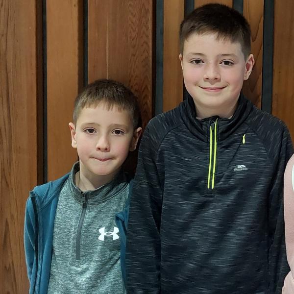 Two boys smiling at the camera.